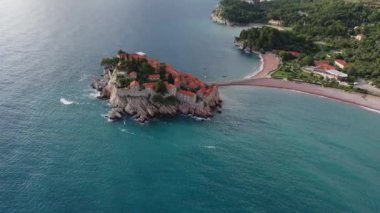 Karadağ 'daki Sveti Stefan tatil beldesi, 4K' lık İHA videosunun etrafındaki şaşırtıcı hava manzarası. Karadağ 'ın küçük eski Sveti Stefan kenti ve tatil beldesi.