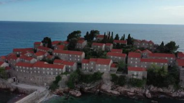 Karadağ 'daki Sveti Stefan tatil beldesi, 4K' lık İHA videosunun etrafındaki şaşırtıcı hava manzarası. Karadağ 'ın küçük eski Sveti Stefan kenti ve tatil beldesi.