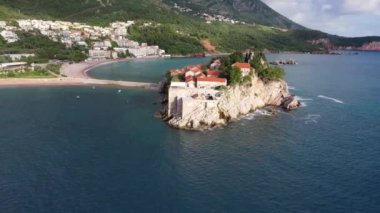 Karadağ 'daki Sveti Stefan tatil beldesi, 4K' lık İHA videosunun etrafındaki şaşırtıcı hava manzarası. Karadağ 'ın küçük eski Sveti Stefan kenti ve tatil beldesi.