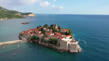 Karadağ 'daki Sveti Stefan tatil beldesi, 4K' lık İHA videosunun etrafındaki şaşırtıcı hava manzarası. Karadağ 'ın küçük eski Sveti Stefan kenti ve tatil beldesi