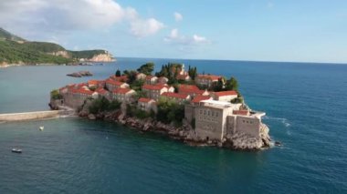 Karadağ 'daki Sveti Stefan tatil beldesi, 4K' lık İHA videosunun etrafındaki şaşırtıcı hava manzarası. Karadağ 'ın küçük eski Sveti Stefan kenti ve tatil beldesi.