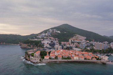 Kırmızı çatıları ve kilise çan kuleleri olan eski ortaçağ taştan evleri. Budva, Karadağ 'ın turizm merkezi ve bir yaz tatili beldesi. Karadağ 'da hava aracı şehir manzarası