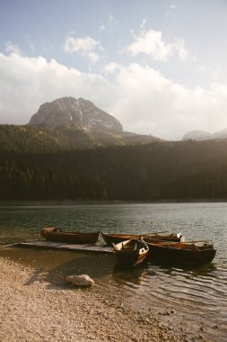 Kuzey Karadağ 'daki Kara Göl veya Crno Jezero manzarası. Avrupa 'nın Zabljak kenti yakınlarındaki Durmitor milli parkında, Kara Göl' ün yakınındaki tahta iskeleye yakın turistik tekneler. Yüksek kalite fotoğraf