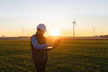 Elektrik mühendisleri rüzgar türbini çalışma jeneratör istasyonu dizüstü bilgisayar ile güç.
