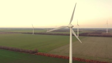 Yükseklerdeki bulutlu gökyüzünde enerji üretimi için güçlü rüzgar türbini çiftliğinin hava manzarası. Rüzgar güç türbinleri sürdürülebilir kalkınma için temiz yenilenebilir enerji üretiyor.