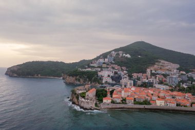 Kırmızı çatıları ve kilise çan kuleleri olan eski ortaçağ taştan evleri. Budva, Karadağ 'ın turizm merkezi ve bir yaz tatili beldesi. Karadağ 'da hava aracı şehir manzarası