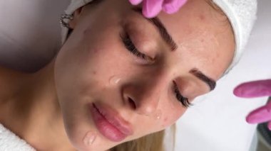 Kapalı gözlerle uzanmış spa salonunda yüz masajı yaptıran oldukça rahat genç bir kadının portresi. Bayan müşteri cilt bakımı tedavisinden zevk alıyor. Sağlık ve güzellik günü konsepti. Yüksek