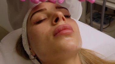 Kapalı gözlerle uzanmış spa salonunda yüz masajı yaptıran oldukça rahat genç bir kadının portresi. Bayan müşteri cilt bakımı tedavisinden zevk alıyor. Sağlık ve güzellik günü konsepti. Yüksek
