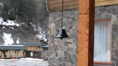 Güçlü bir rüzgar eski çanı sallıyor. Binanın dışı ve tasarım ayrıntıları eski moda.