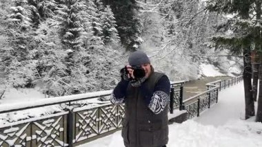 Fotoğrafçı, karla kaplı ağaçlar ve bir dağ nehri çekiyor. Amatör fotoğrafçı gezgin, kamera parkında ve doğada çekim yapıyor.. 