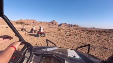 Mısır 'ın Sharm el Sheikh yakınlarındaki çölde bisiklet sürmek. ATVSand ve Sand Borkhan' daki çöl off-road maceraları. Kaya ve gün batımı. Dörtlü Bisiklet Seyahati. İnsanlarla Gezinti. 