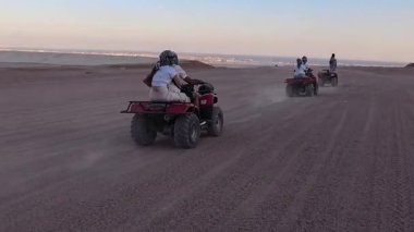 Mısır 'ın Sharm el Sheikh yakınlarındaki çölde bisiklet sürmek. ATVSand ve Sand Borkhan' daki çöl off-road maceraları. Kaya ve gün batımı. Dörtlü Bisiklet Seyahati. İnsanlarla Gezinti. 