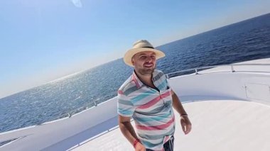 Şapkalı mutlu adam denizdeki teknesiyle Kızıl Deniz 'de yat gezintisi yapıyor.. 