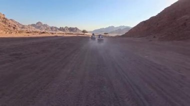 Mısır 'ın Sharm el Sheikh yakınlarındaki çölde bisiklet sürmek. ATVSand ve Sand Borkhan' daki çöl off-road maceraları. Kaya ve gün batımı. Dörtlü Bisiklet Seyahati. İnsanlarla Gezinti. 