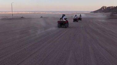 Mısır 'ın Sharm el Sheikh yakınlarındaki çölde bisiklet sürmek. ATVSand ve Sand Borkhan' daki çöl off-road maceraları. Kaya ve gün batımı. Dörtlü Bisiklet Seyahati. İnsanlarla Gezinti. 