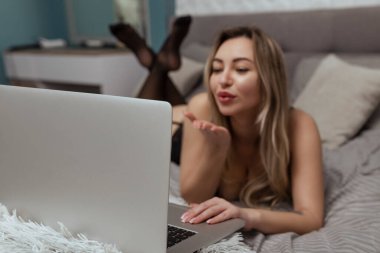 Güzel, genç bir kız webcam çekiyor, kameraya bir öpücük yolluyor, manken olarak çalışıyor. İnternette flört etme, internette seks..