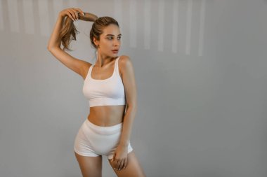 Mükemmel bir göbek ve kalça şekli. Gri stüdyo arka planında izole edilmiş beyaz iç çamaşırlı zayıf bir kadının güzel vücudu. Sağlık, kilo kaybı, tedavi, sağlık sigortası, fitness konsepti. El ilanı. 