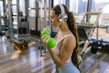 Spor salonunda dumbbells ile çalışma dışarı çekici genç kadın