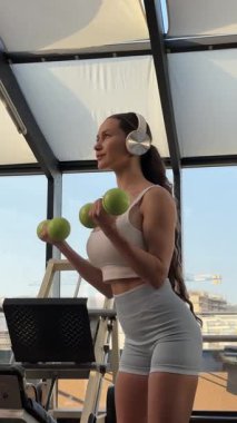 Spor salonunda dumbbells ile çalışma dışarı çekici genç kadın
