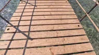 Kuşlar merdivenlerden aşağı bakar, sahile giden merdivenler, tahta güvertede çıplak ayakla yürüyen adam, deniz, güneş ışığı. Yüksek kalite 4k görüntü