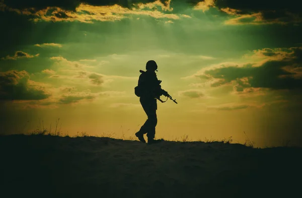 日落时拿着来复枪站在背后的美军士兵的轮廓 — 图库照片