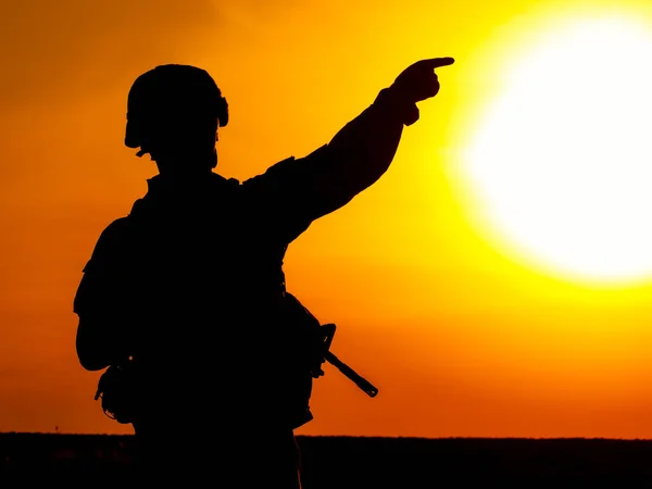 背景に太陽が沈むにつれて 日没時にライフルを持つ米軍兵士のシルエット — ストック写真