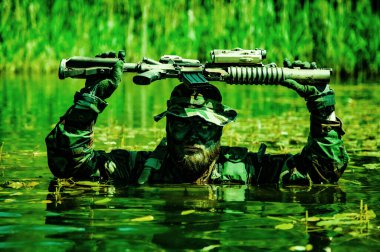 Bir asker bataklığın göbeğinde hareket eder, bataklık sularına batar, sadece silah ve tüfekle görünür, özel görev kuvvetlerinin gizli taktiksel savaş operasyonlarının aşırı koşulları