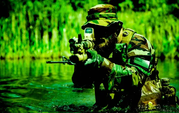 Ein Fokussierter Soldat Der Mit Seinem Gewehr Sumpfgebiet Steht Sich Stockbild