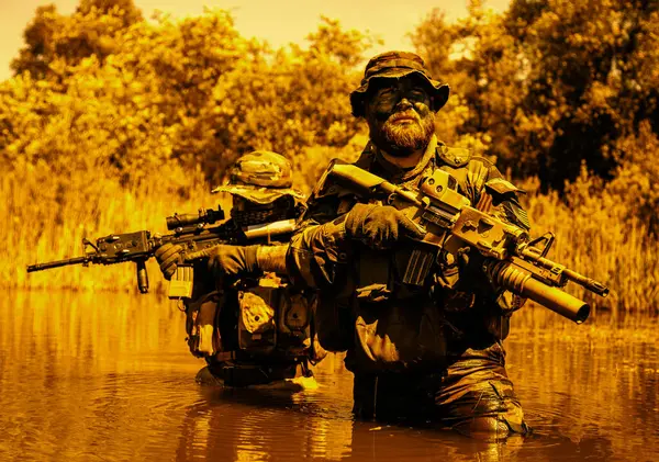 士兵们在沼泽地的中心移动 穿过沼泽的水域 热带丛林的高温 特遣部队隐蔽战术作战的极端条件 图库照片