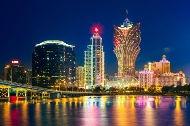 skyline of macau by the sea at night in china clipart
