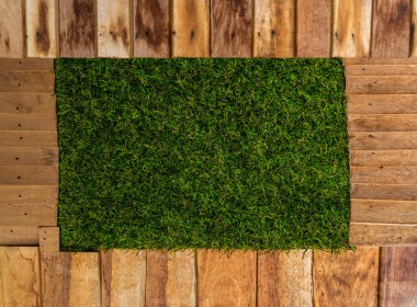 Ahşap ve çimlerle süslenmiş taş bir duvar parçası..