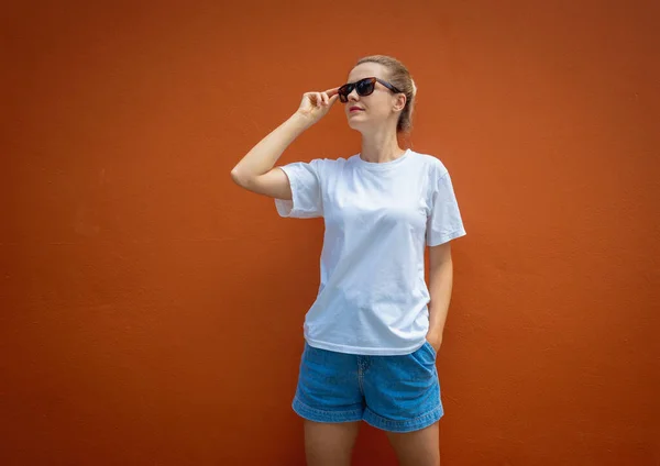 Turuncu Bir Duvarın Arka Planında Beyaz Tişört Giyen Kadın Model — Stok fotoğraf