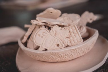 Atölyedeki masada seramik oyuncaklar.