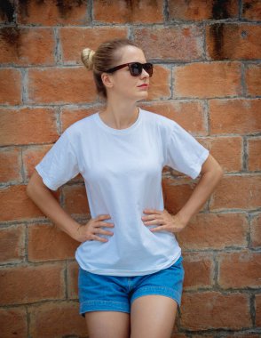 Duvarın arka planında beyaz tişört giyen kadın model.