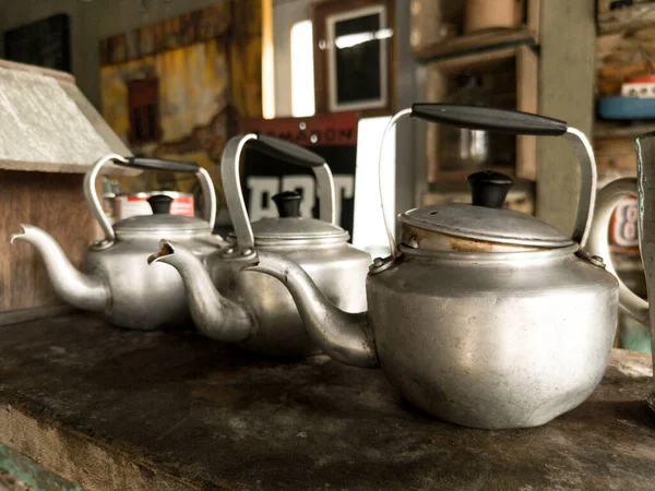 Alüminyum çaydanlıklar ve karanlık bir arka planda soba..