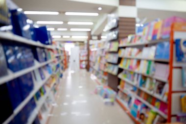 Kitapçının arka planında raflarda farklı kitaplar var..