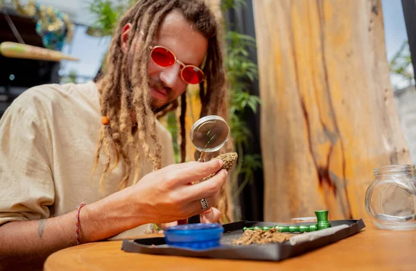 Hippie Style Man Examines Magnifying Glass Joints Buds Medical Marijuana — Stock Photo, Image