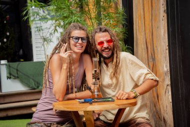 Hippi tarzı bir çift tıbbi marihuanayla sigara içiyor..