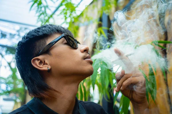 医療用マリファナでタバコを吸う若い男 — ストック写真
