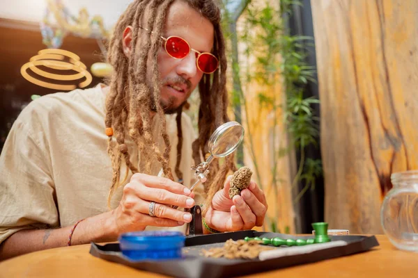 Hippie Styl Muž Zkoumá Pod Lupou Klouby Pupeny Lékařské Marihuany — Stock fotografie