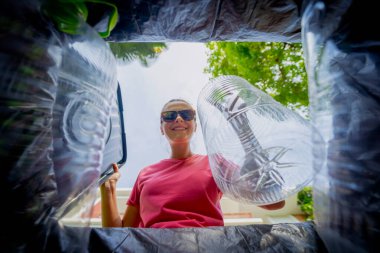 Genç ve güzel bir kız özel çöp kutularına çöp atıyor..