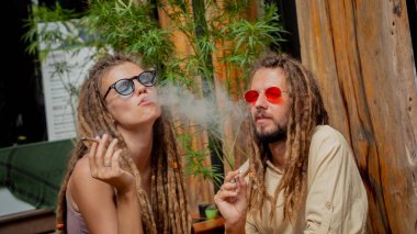 Hippi tarzı bir çift tıbbi marihuanayla sigara içiyor..