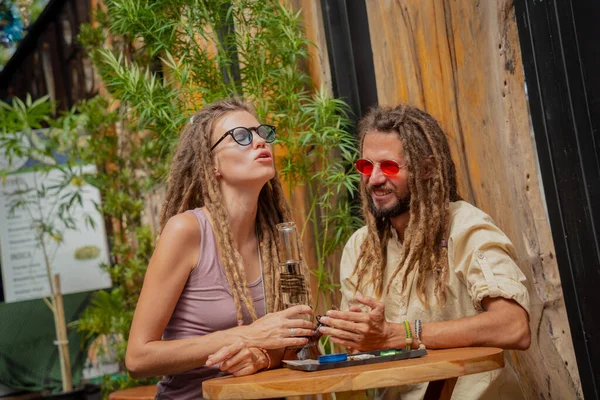 Hippie Style Couple Smoking Medical Marijuana Using Bong — Stockfoto