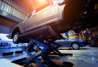 Otomobil tamirhanesinde hidrolik asansördeki araba..