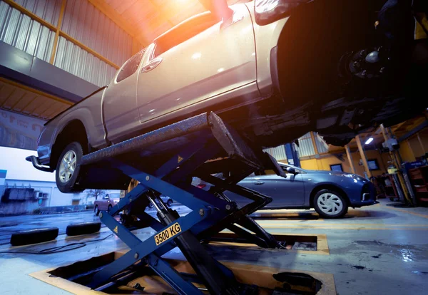 Otomobil tamirhanesinde hidrolik asansördeki araba..