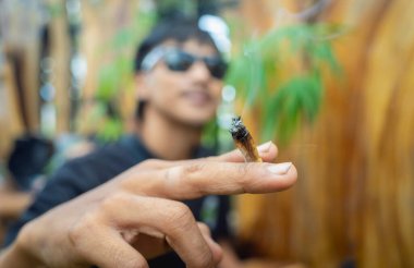 Genç adam tıbbi marihuanayla sigara içiyor..