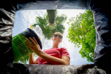 Genç ve güzel bir kız özel çöp kutularına çöp atıyor..