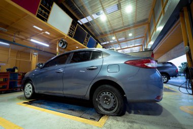 Car with a punctured and broken wheel in a car repair shop.