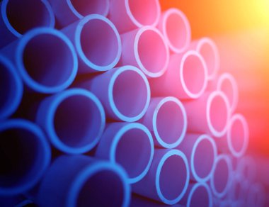 Üst üste dizilmiş mavi plastik boruların arkaplanı.