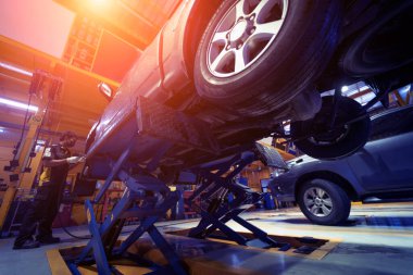 Otomobil tamirhanesinde hidrolik asansördeki araba..